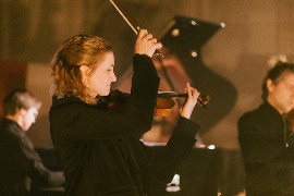 Frau mitten im Konzert mit Geige